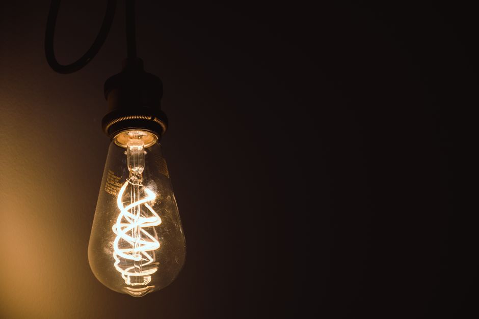 Close-up of a glowing Edison light bulb showcasing its intricate filament.