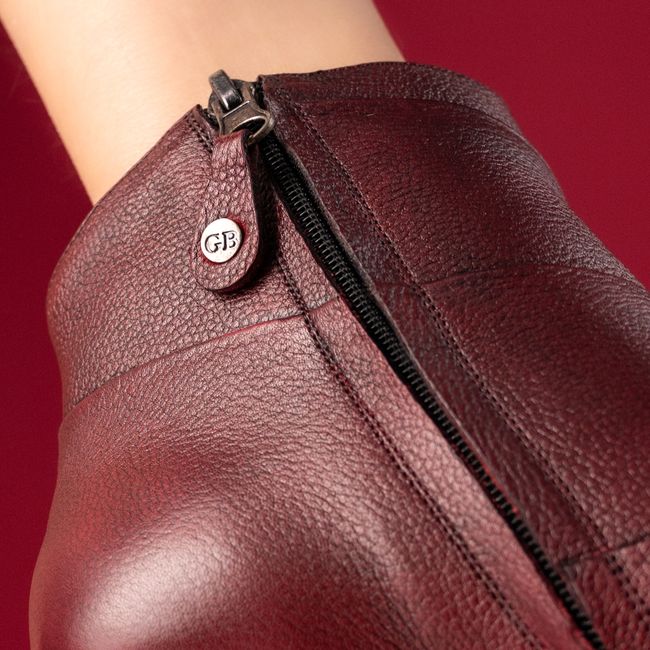 Elegant burgundy leather boots with zip detail for a chic fashion statement.