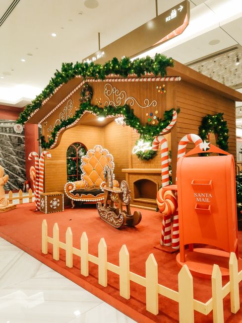 Christmas gingerbread house with festive decor and Santa mail in a mall.